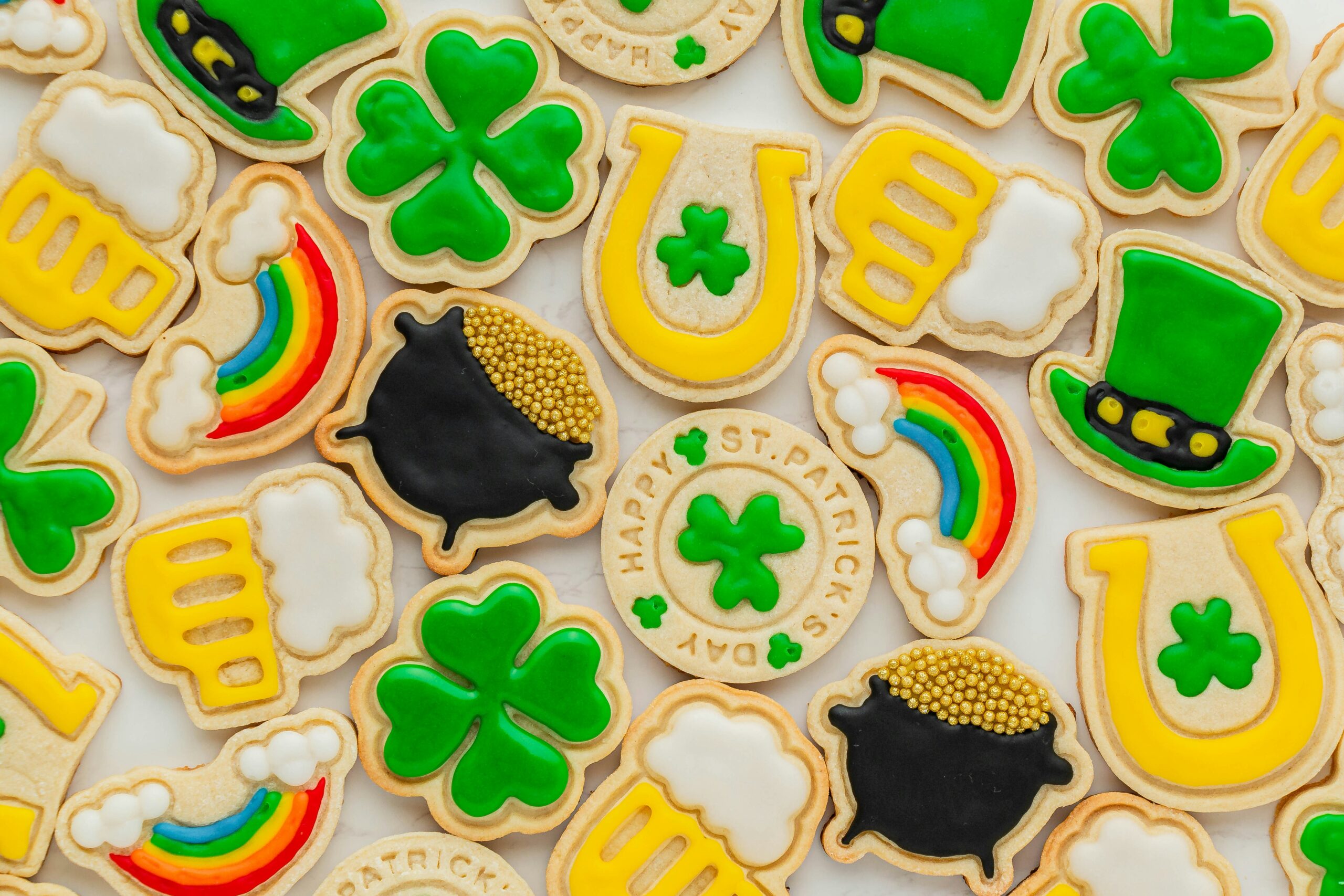 ices cut out cookies in the shape of rainbows, shamrocks, and pints for St. Patrick's day